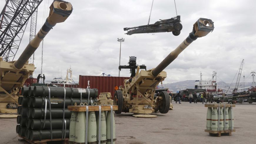 Workers unload artillery, part of a military donation from the U.S. government to the Lebanese army, during a ceremony at Beirut's port February 8, 2015. More than 70 M198 Howitzers, as well as 26 million rounds of ammunition including small, medium, and heavy artillery rounds, were delivered on Sunday  from the United States as military aid to the Lebanese army. REUTERS/Mohamed Azakir (LEBANON - Tags: POLITICS MILITARY) - GM1EB281REZ01