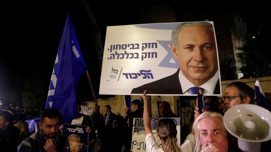 Supporters of Israeli Prime Minister Benjamin Netanyahu protest outside his residence following Israel's Attorney General Avichai Mandelblit's indictment ruling in Jerusalem November 21, 2019. The placards in Hebrew read, "Strong in security Strong in Economy ". REUTERS/Ronen Zvulun - RC2UFD9194FK