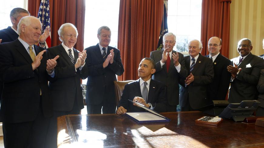 U.S. President Barack Obama (seated) signs H.R. 6156, the Russia and Moldova Jackson-Vanik Repeal and Magnitsky Rule of Law Accountability Act, in the Oval Office of the White House in Washington, December 14, 2012. From L-R are: U.S. Sen. Ben Cardin, U.S. Sen. Joe Lieberman, U.S. Sen. Max Baucus, Obama, U.S. Rep. Steny Hoyer, U.S. Rep. Sandy Levin, U.S. Rep. Jim McGovern, and U.S. Rep. Gregory Meeks.      REUTERS/Larry Downing  (UNITED STATES - Tags: POLITICS) - GM1E8CF053K01