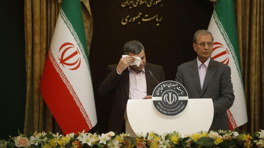 Iranian Deputy Health Minister Iraj Harirchi (L) wipes the sweat off his face, during a press conference with the Islamic republic's government spokesman Ali Rabiei in the capital Tehran on February 24, 2020. - Iran's deputy health minister confirmed on February 25, that he has tested positive for the novel coronavirus, amid a major outbreak in the Islamic republic. Harirchi coughed occasionally and appeared to be sweating during the press conference with Rabiei in Tehran. (Photo by Mehdi BOLOURIAN / FARS N