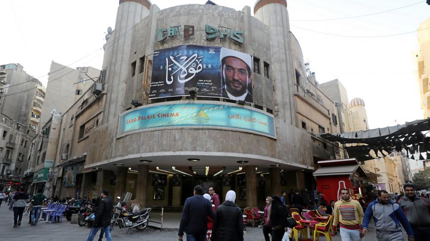 Egyptians walk past an advertisement featuring the Egyptian film "Mawlana" ("The Preacher") at a cinema in Cairo, Egypt January 23, 2017. REUTERS/Mohamed Abd El Ghany - RC1CBD0FE750