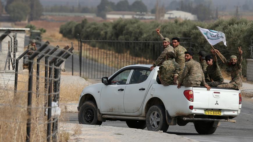 Turkish-backed Syrian rebels ride their vehicle on a street in the Turkish border town of Akcakale in Sanliurfa province, Turkey, October 16, 2019. REUTERS/Stoyan Nenov - RC1FAB8C4260