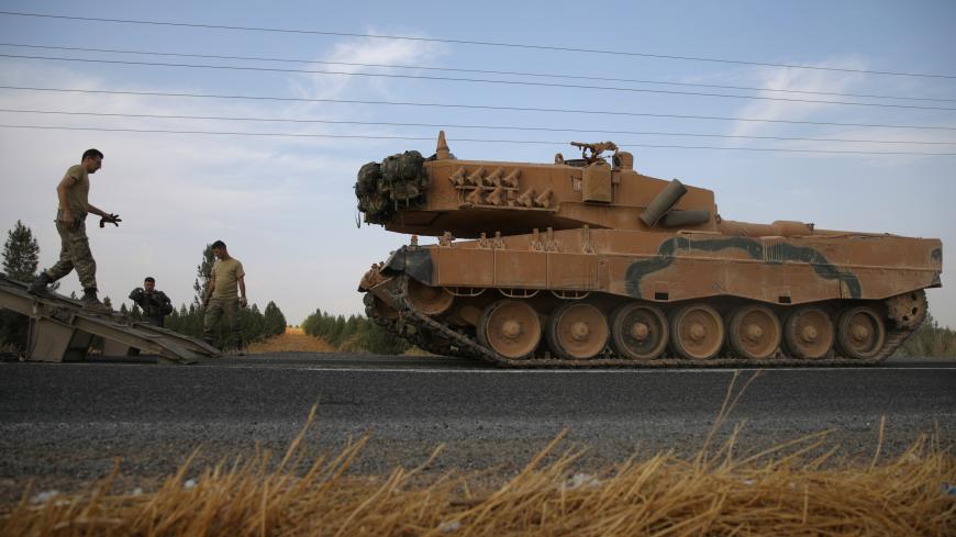 Turkish army tank is being unloaded on a road near the Turkish border town of Ceylanpinar, Sanliurfa province, Turkey, October 18, 2019. REUTERS/Stoyan Nenov - RC1C41D0BF40