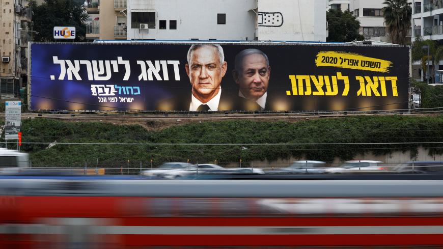 Traffic moves past a Blue and White party election campaign poster, depicting party leader Benny Gantz, and Israeli Prime Minister Benjamin Netanyahu, in Tel Aviv, Israel February 18, 2020. REUTERS/Amir Cohen - RC243F9KEJJJ