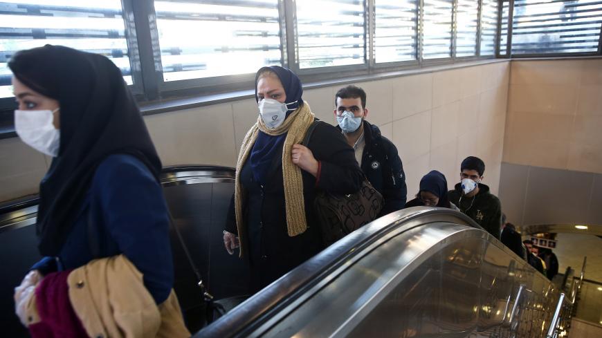 Iranian people wear protective masks to prevent contracting a coronavirus, as they climb an escalator in Tehran, Iran February 29, 2020. WANA (West Asia News Agency)/Nazanin Tabatabaee via REUTERS ATTENTION EDITORS - THIS PICTURE WAS PROVIDED BY A THIRD PARTY - RC2BAF97VRQP