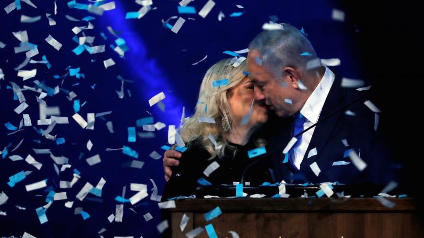 Confetti falls as Israeli Prime Minister Benjamin Netanyahu kisses his wife Sara after speaking to supporters following the announcement of exit polls in Israel's election at his Likud party headquarters in Tel Aviv, Israel March 3, 2020. REUTERS/Ammar Awad     TPX IMAGES OF THE DAY - RC20CF9VHWZV