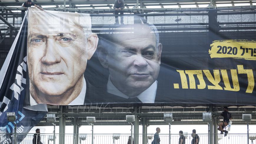 TEL AVIV, ISRAEL - FEBRUARY 17:  Workers hang a Blue and White Party billaboard showing its leader Benny Gantz and Israeli Prime Minister, Benjamin Netanyahu, as part of the party's campaign on February 17, 2020 in Tel Aviv, Israel. In two weeks Israelis will head to the polls for the third election in less than a year.  (Photo by Amir Levy/Getty Images)