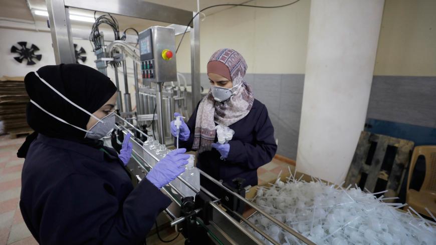 Palestinian women work in a sanitiser factory amid precautions against the coronavirus, in Hebron in the Israeli-occupied West Bank March 12, 2020.REUTERS/Mussa Qawasma - RC2DIF9G27AF
