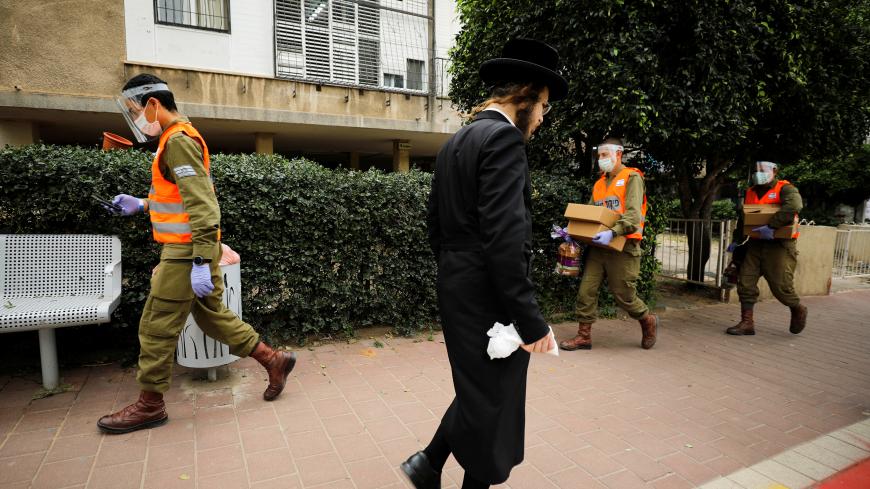 Israeli soldiers deliver food to residents in Bnei Brak, an ultra-Orthodox Jewish town badly affected by the coronavirus disease (COVID-19), and which Israel declared a "restricted zone" due to its high rate of infections, near Tel Aviv, Israel April 5, 2020. REUTERS/Amir Cohen - RC2BYF9AZODO