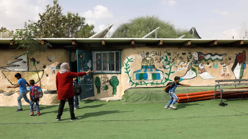 Palestinian Bedouin schoolchildren play in the yard of their school in the Palestinian Bedouin village of Khan al-Ahmar, east of Jerusalem, in the occupied West Bank, on October 21, 2018. - Israeli Prime Minister Benjamin Netanyahu has frozen plans to demolish a strategically located Bedouin village in the occupied West Bank that has drawn the world's attention, his office said on October 21. "The intention is to give a chance to the negotiations and the offers we received from different bodies, including i