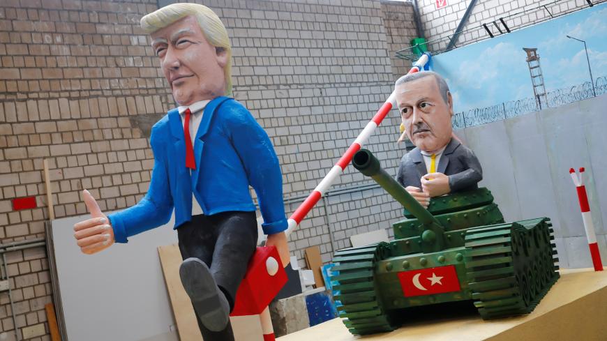 U.S. President Donald Trump is depicted as border barrier opener for Turkey's President Recip Tayyip Erdogan, who sits on a tank, during a sneak preview for the upcoming Rose Monday carnival parade in Cologne, Germany, February 18, 2020. REUTERS/Wolfgang Rattay - RC213F97TGLM
