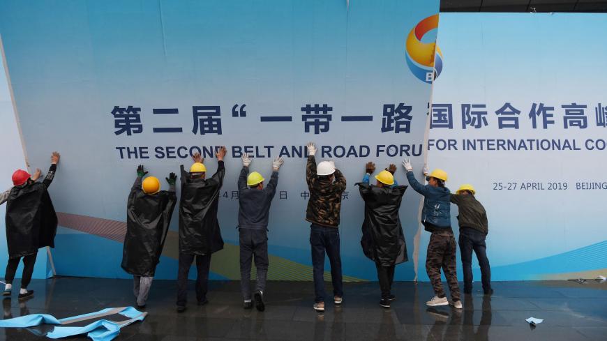 Workers take down a Belt and Road Forum panel outside the venue of the forum in Beijing on April 27, 2019. - Chinese President Xi Jinping urged dozens of world leaders on April 27 to reject protectionism and invited more countries to participate in his global infrastructure project after seeking to ease concerns surrounding the programme. (Photo by GREG BAKER / AFP)        (Photo credit should read GREG BAKER/AFP via Getty Images)
