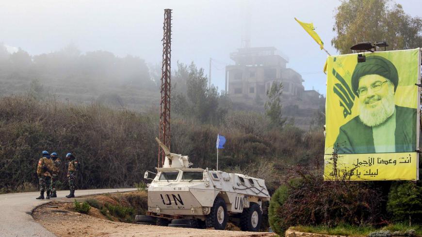 A United Nations Interim Forces in Lebanon (UNIFIL) armoured vehicle is parked under a portrait of Hezbollah leader Hassan Nasrallah on a side road in the southern Lebanese town of Kfar Kila near the border with Israel on January 3, 2020. - Following this morning's killing of Iranian commander, Major General Qasem Soleimani, Lebanon's Iran-backed Hezbollah movement called for the missile strike by Israel's closest ally, to be avenged. "Meting out the appropriate punishment to these criminal assassins... wil