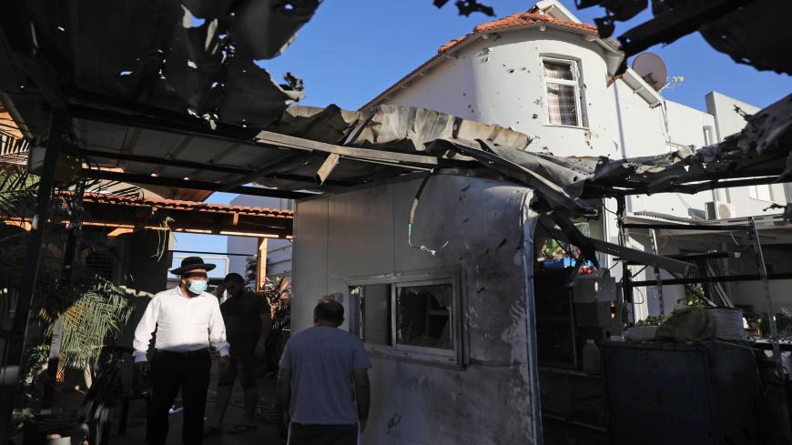 People inspect the damages at a house that was hit by a rocket launched from Gaza to the southern Israeli city of Sderot, early morning on August 16, 2020. (Photo by Menahem KAHANA / AFP) (Photo by MENAHEM KAHANA/AFP via Getty Images)
