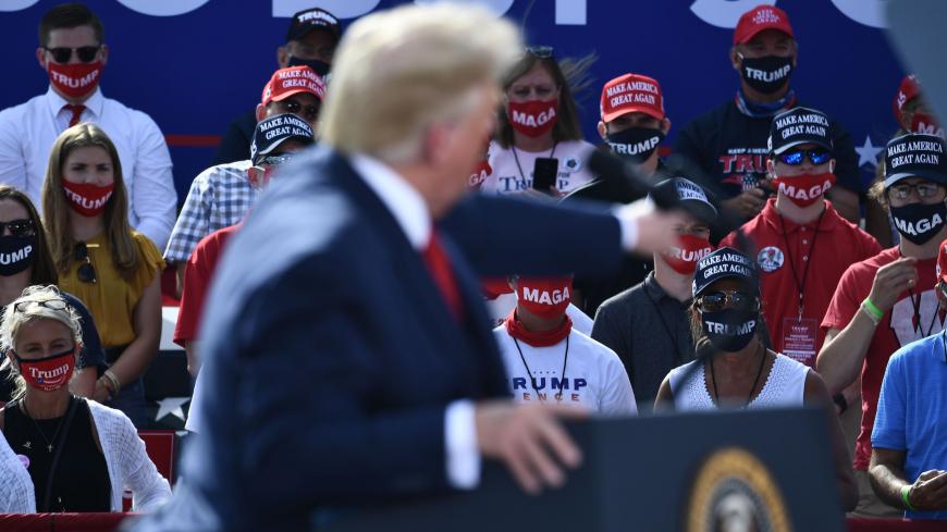 People wear facemasks as US President Donald Trump delivers remarks on the economy at an airport hangar on August 17, 2020 in Oshkosh, Wisconsin. (Photo by Brendan Smialowski / AFP) (Photo by BRENDAN SMIALOWSKI/AFP via Getty Images)