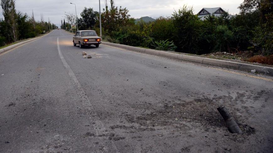 A picture taken on September 28, 2020 shows an unexploded artillery shell on a road on the outskirts of the Azerbaijani city of Tartar during clashes between Armenian separatists and Azerbaijan over the breakaway Nagorny Karabakh region. (Photo by Tofik BABAYEV / AFP) (Photo by TOFIK BABAYEV/AFP via Getty Images)