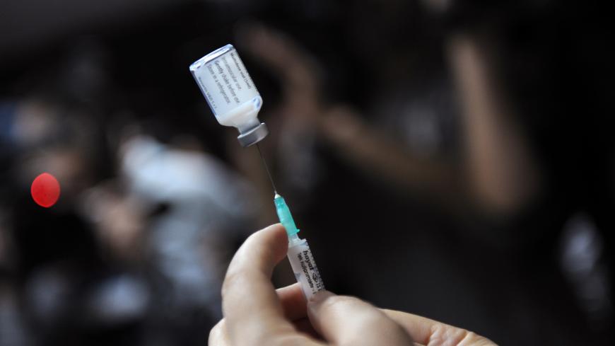 A nurse prepares a shot of the A(H1N1) vaccine (Pandemrix from Glaxo Smith Kline -GSK- laboratory) to a hospital staff member in Istanbul, on November 2, 2009. Turkey began vaccinating medical workers Monday as the death toll from the A(H1N1) virus in the country reached six, the health ministry said.   The latest victims of the disease were a 22-month-old baby and a 14-year-old boy who died overnight in the central city of Konya, a ministry statement said. Nine other people infected with swine flu were in 