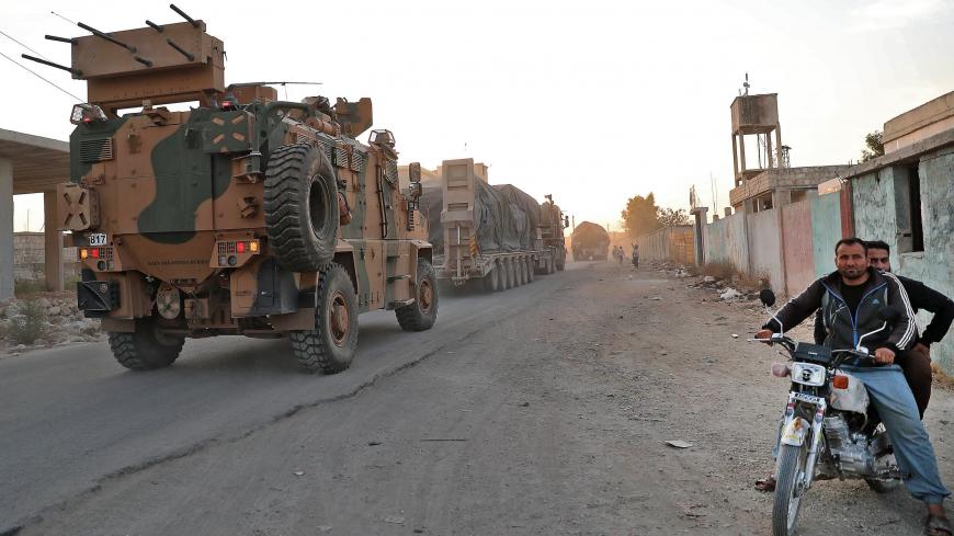 A Turkish military convoy drives through the village of Iblin, near Ariha in Syria's rebel-held northwestern Idlib province on October 20, 2020 after vacating the Morek post in Hama's countryside. - Turkey started withdrawing from one of its largest outposts in northwest Syria encircled for the past year by Syrian regime forces, a war monitor and a pro-Ankara rebel commander said. The outpost in Morek is Turkey's largest in the northwest province of Hama, which is now mostly under Syrian government control.