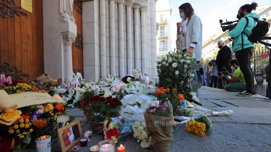 A woman pays homage in front of the Notre-Dame de l'Assomption Basilica in Nice on October 30, 2020 during a tribute to the victims killed by a knife attacker the day before. - A 47-year-old man believed to have been in contact with the suspected knifeman who killed three at a church in Nice has been detained for questioning, a judicial source said on October 30, 2020. The man was detained late Thursday after the attack at the city's Notre-Dame basilica by a 21-year-old Tunisian who arrived in France on Oct