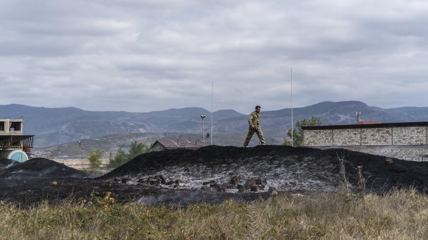 STEPANAKERT, NAGORNO-KARABAKH - OCTOBER 2:  An emergency services member stands atop the site of a grass fire started by a bomb that fell nearby on October 2, 2020 in Stepanakert, Nagorno-Karabakh. A decades-old conflict between Armenia and Azerbaijan has reignited in the disputed region of Nagorno-Karabakh, recognized by most countries as part of Azerbaijan, but controlled by ethnic Armenians since a 1994 ceasefire. Dozens have been reported killed in the recent fighting, in which both countries blame the 