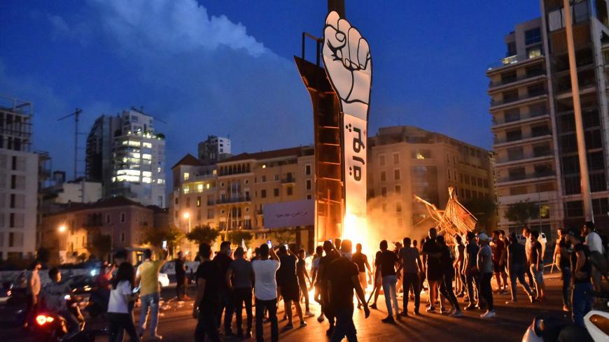 Lebanese youths gather around the Revolution fist, symbol of Lebanons October 2019 uprising, after it was set on fire during clashes between anti-government protesters and supporters of former prime minister Saad Hariri, in the capital Beirut's central Martyr's square, on October 21, 2020. - Hariri resigned as premier in October 2019 in the wake of unprecedented street protests, but he is now expected to make a comeback at the helm of the next government.
Most parliamentary blocs have pledged support for Ha