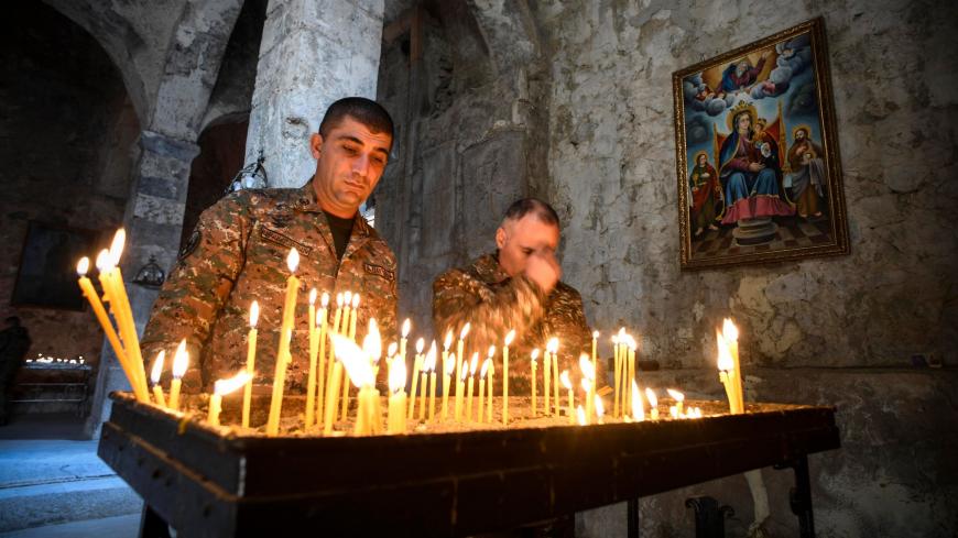 TOPSHOT - Armenian soldiers light candles as they pay a final tribute to fallen comrades at the 12th-13th century Orthodox Dadivank Monastery on the outskirts of Kalbajar on November 12, 2020, during the military conflict between Armenia and Azerbaijan over the breakaway region of Nagorno-Karabakh. - Kalbajar is one of the seven districts which will be transferred to Azerbaijan as part of a deal on Nagorno-Karabakh. (Photo by Alexander NEMENOV / AFP) (Photo by ALEXANDER NEMENOV/AFP via Getty Images)