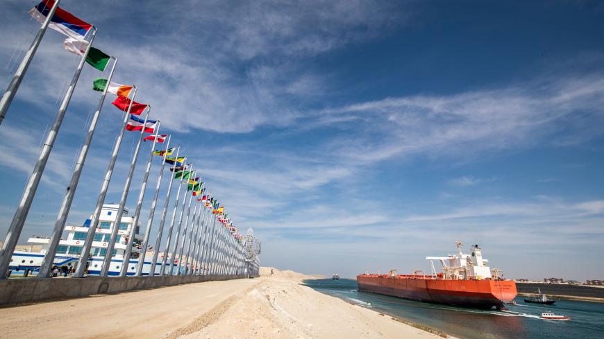 This picture taken on November 17, 2019 shows the Malaysia-flagged oil tanker Bunga Kasturi sailing through Egypt's Suez Canal in the canal's central hub city of Ismailia on the 150th anniversary of the canal's inauguration. - One hundred and fifty years after the Suez Canal opened, the international waterway is hugely significant to the economy of modern-day Egypt, which nationalised it in 1956. The canal, dug in the 19th century using "rudimentary tools" and which links the Mediterranean to the Red Sea, w