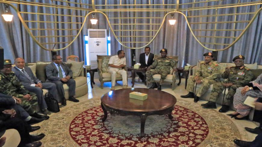 Ethiopia's Prime Minister Abiy Ahmed (C-L) meets with members of Sudan's ruling military council after his arrival at Khartoum international airport on June 7, 2019. - Ethiopia's prime minister arrived in Khartoum on June 7, seeking to broker talks between the ruling generals and protesters, as heavily armed paramilitaries remained deployed in some squares of the Sudanese capital after a deadly crackdown, leaving residents in 'terror'. (Photo by ASHRAF SHAZLY / AFP)        (Photo credit should read ASHRAF S