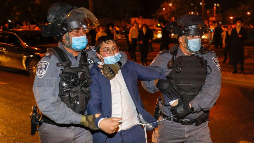 Israeli security forces arrest an Ultra-Orthodox Jewish man during a protest against the enforcement of coronavirus emergency regulations, in the Ultra Orthodox jewish neighborhood of Mea Shearim, in Jerusalem, on October 5, 2020. (Photo by AHMAD GHARABLI / AFP) (Photo by AHMAD GHARABLI/AFP via Getty Images)