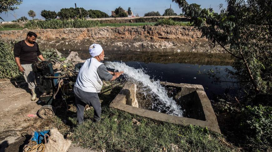 Egyptian farmer Mohamed Omar (C), 65, supplies his farmland with water from a canal, fed by the Nile river, in the village of Baharmis on the outskirts of Egypt's Giza province, northwest of the capital Cairo, on December 1, 2019. - Egypt has for years been suffering from a severe water crisis that is largely blamed on population growth. Mounting anxiety has gripped the already-strained farmers as the completion of Ethiopia's gigantic dam on the Blue Nile, a key tributary of the Nile, draws nearer. Egypt vi
