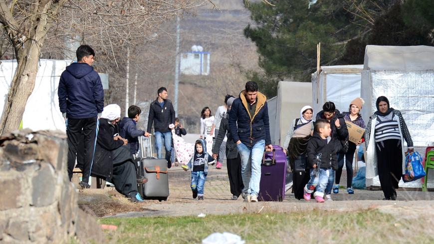 Yazidis refugees carry their belongings on January 3, 2017 in Diyarbakir, southeastern Turkey as they change their refugee camp and move to Midyat, further south.
The population of Yazidis reaches 700,000, the majority residing in northern Iraq where persecution from Islamic State jihadists led to as many as 40,000 Yazidis fleeing their ancestral homes to the Sinjar Mountains in northwestern Iraq, where they were trapped without food or water. / AFP / ILYAS AKENGIN        (Photo credit should read ILYAS AKE