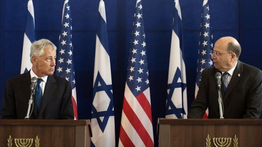 U.S. Defense Secretary Chuck Hagel (L) listens as his Israeli counterpart Moshe Yaalon speaks during a joint news conference at Kirya base in Tel Aviv April 22, 2013. Israel suggested on Monday it would be patient before taking any military action against Iran's nuclear programme, saying during a visit by Hagel there was still time for other options. REUTERS/Jim Watson/Pool (ISRAEL - Tags: POLITICS) - RTXYVS7