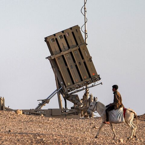 A boy rides a donkey near one of the batteries of Israel's Iron Dome missile defense.