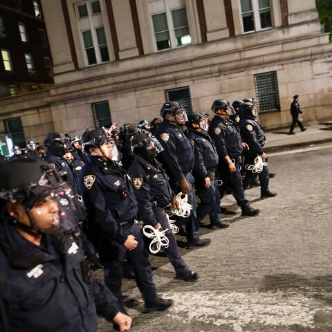 NYPD officers in riot gear march onto Columbia University campus, where pro-Palestinian students are barricaded inside a building and have set up an encampment, in New York City on April 30, 2024. Columbia University normally teems with students, but a "Free Palestine" banner now hangs from a building where young protesters have barricaded themselves and the few wandering through campus generally appear tense. Students here were among the first to embrace the pro-Palestinian campus encampment movement, whic