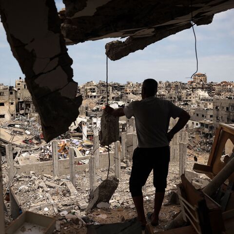  A Palestinian man looks at a ravaged neighborhood from a destroyed apartment in Khan Younis in the southern Gaza Strip, May 2, 2024.