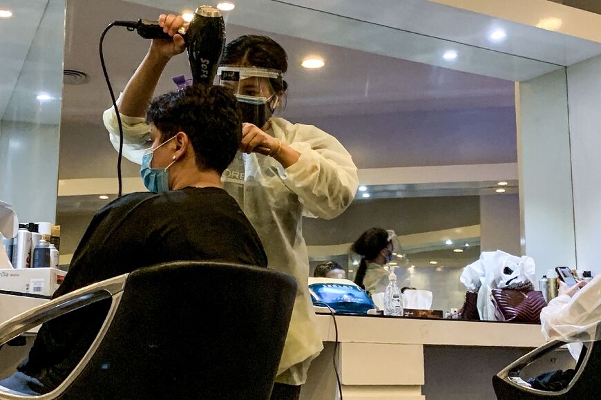 In this file photo taken on June 21, 2020, a hairdresser blow-dries a client's hair at a women's beauty centre in Riyadh as the country begins to re-open following the lifting of a coronavirus lockdown