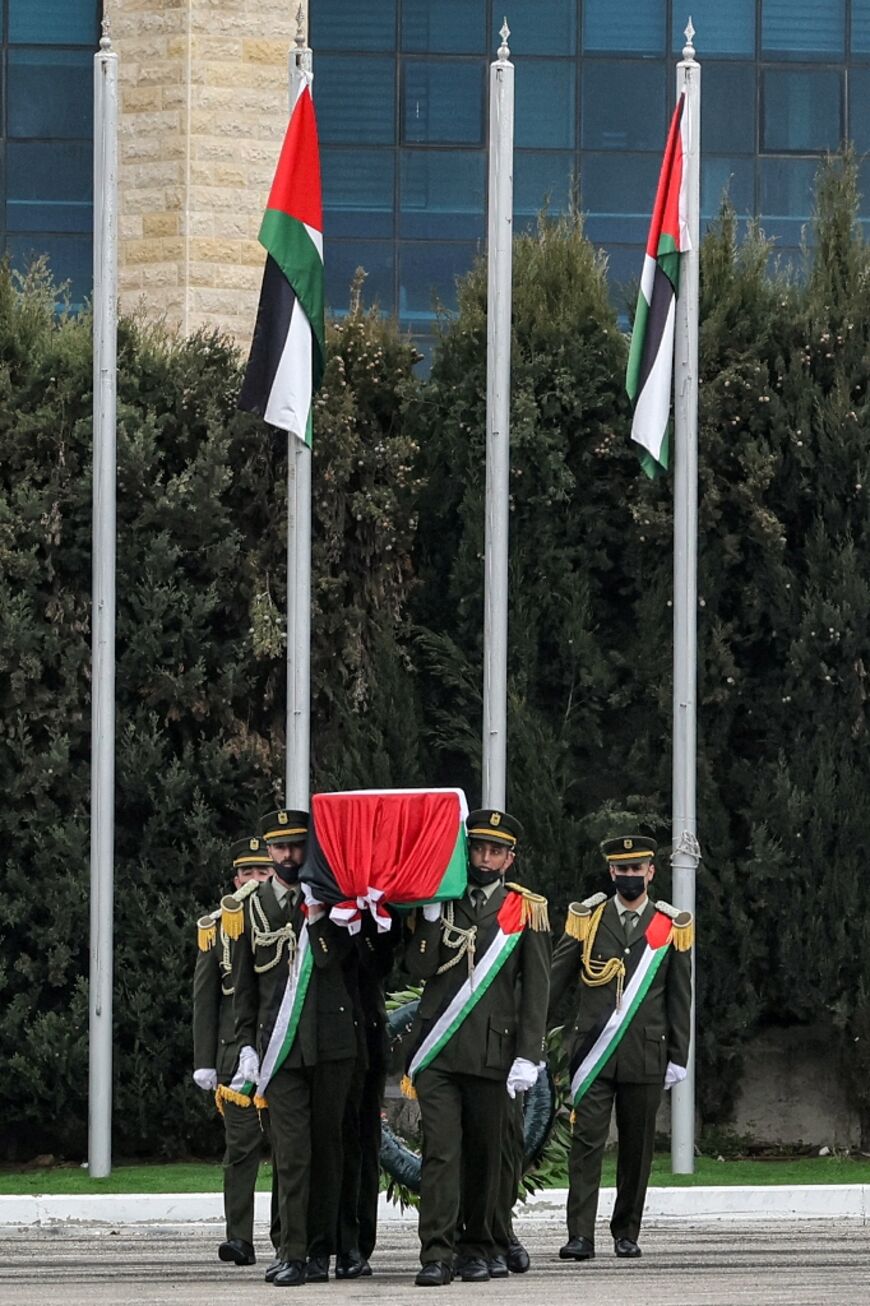 An honour guard carries the flag-draped coffin of Ahmad Qorei during his funeral in Ramallah in the occupied West Bank