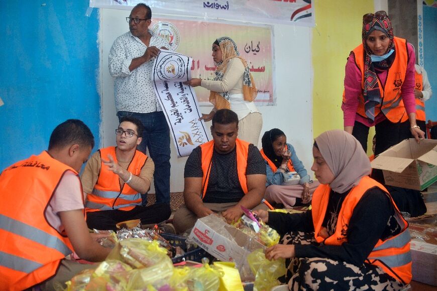 Volunteers prepare aid packages for refugees fleeing Sudan, at the Wadi Karkar bus station near the Egyptian city of Aswan