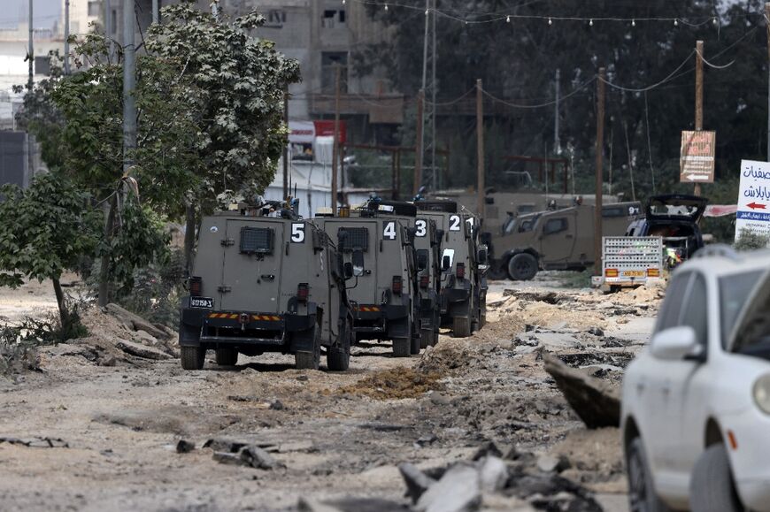 An Israeli armoured column drives down a street in the camp which has been stripped of its asphalt by army bulldozers