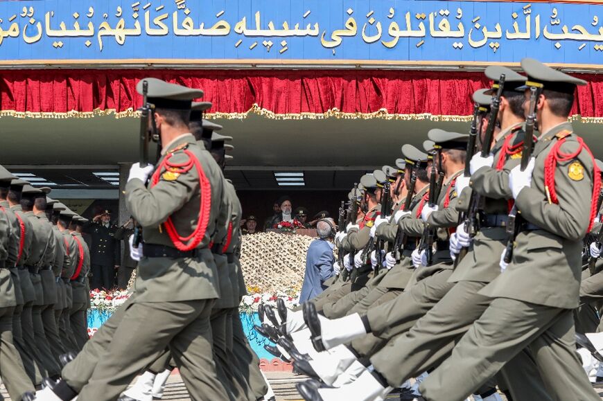 Soldiers march past Iran's President Ebrahim Raisi during a military parade in Tehran on April 17, 2024