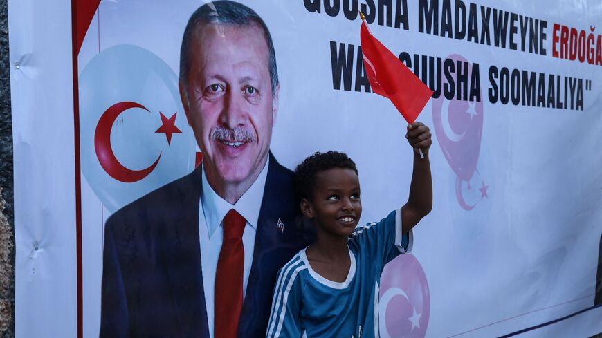 A Somali boy holds a Turkish national flag as people celebrate the victory of Turkish President Recep Tayyip Erdogan after he won the presidential run-off election in Mogadishu, on May 29, 2023. (Photo by Hassan Ali Elmi / AFP) (Photo by HASSAN ALI ELMI/AFP via Getty Images)