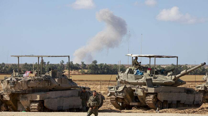 Israeli army tanks take position in southern Israel near the border with the Gaza Strip as smoke billows over Gaza during Israeli bombardment on May 6, 2024, amid the ongoing conflict between Israel and the Palestinian Hamas movement. (Photo by Menahem KAHANA / AFP) (Photo by MENAHEM KAHANA/AFP via Getty Images)