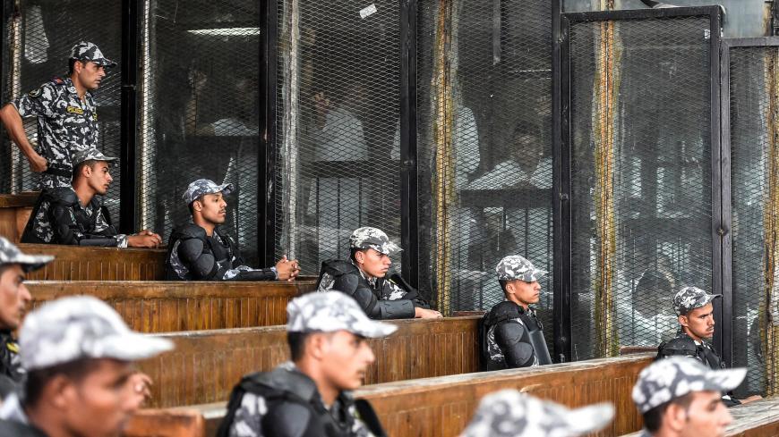 Members of Egypt's banned Muslim Brotherhood are seen inside a glass dock during their trial in the capital Cairo on July 28, 2018