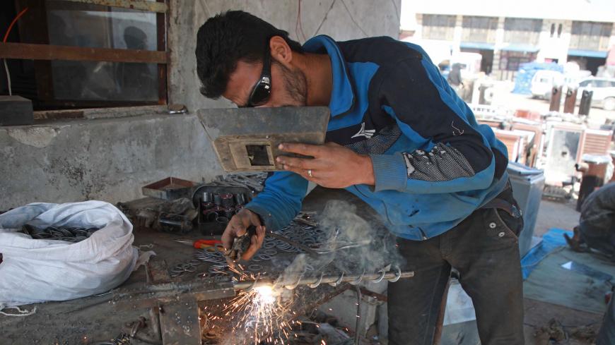 A Syrian labourer works at a workshop specialised in building pistachio-powered heaters in al-Dana town in Syria's northwestern province of Idlib on December 18, 2019.