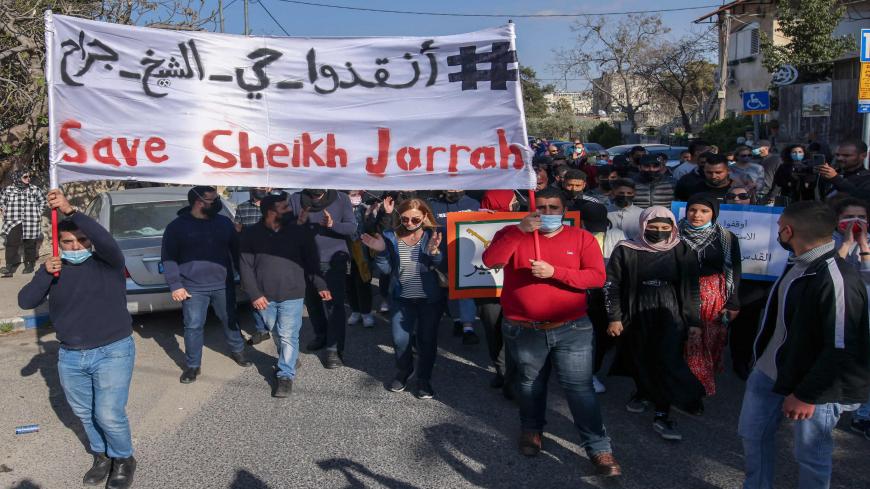 Palestinian, Israeli and foreign activists lift banners and placards during a demonstration against Israeli occupation and settlement activity in the Palestinian territories and East Jerusalem, Sheikh Jarrah neighborhood, Jerusalem, March 19, 2021.