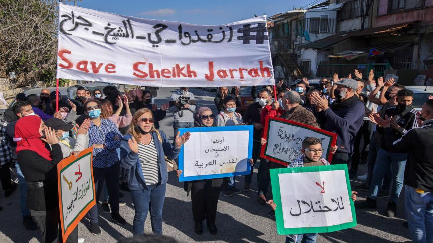 Palestinian, Israeli and foreign activists lift banners and placards during a demonstration against the Israeli occupation and settlement activity in the Palestinian territories and East Jerusalem, Sheikh Jarrah neighborhood, Jerusalem, March 19, 2021.
