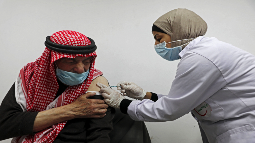 An elderly Palestinian man receives a shot of the Covid-19 coronavirus vaccine in the West Bank city of Nablus on March 22, 2021. - Palestinian authorities started vaccinating the elderly and those with chronic illness. (Photo by JAAFAR ASHTIYEH/AFP via Getty Images)