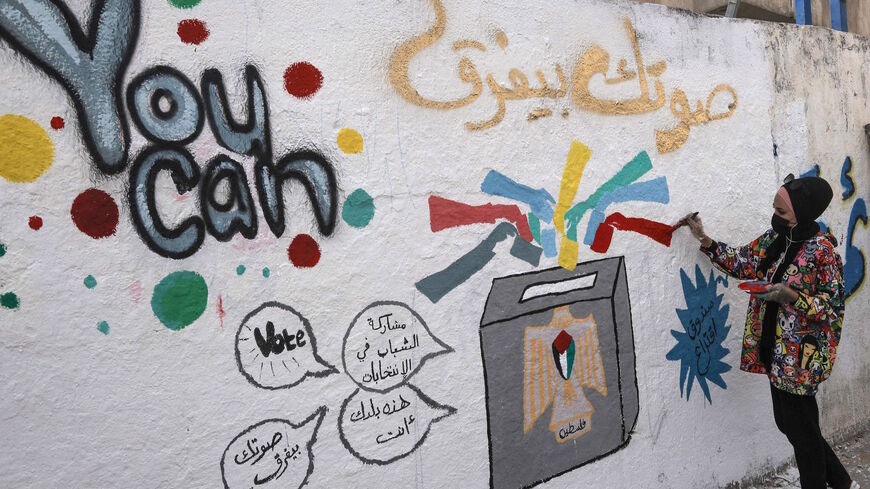 A Palestinian artist adds the final touches to a mural painting calling on people to vote during the upcoming elections (legislative in May and presidential in July) in a street in Gaza City, on March 24, 2021.