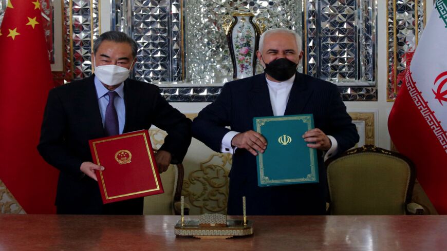 Iranian Foreign Minister Mohammad Javad Zarif (R) and his Chinese counterpart, Wang Yi, pose for a picture after signing an agreement in the capital, Tehran, on March 27, 2021. Iran and China signed what state television called a "25-year strategic cooperation pact" today as the US rivals move closer together. The agreement, which has been kept almost entirely under wraps, was signed by the two countries' foreign ministers, Mohammad Javad Zarif and Wang Yi, an AFP correspondent reported. 