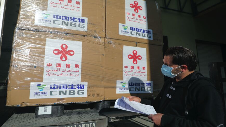A Palestinian worker unloads a shipment of the Sinopharm COVID-19 vaccines donated by the Chinese government in the West Bank city of Nablus, on March 29, 2021. 